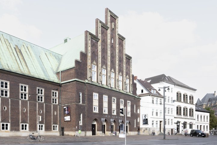 Exterior view of Die Glocke with a bicycle and street view.