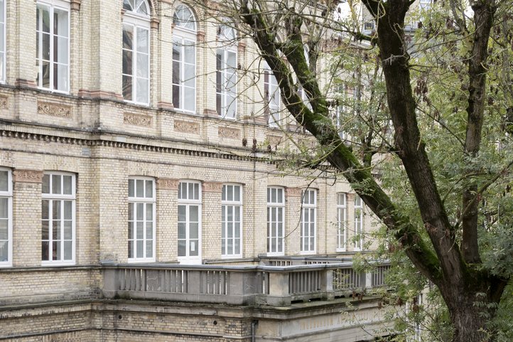Historisches Backsteingebäude in der Dechanatstraße, das den Fachbereich Musik der HfK Bremen beherbergt, teilweise von Bäumen verdeckt.