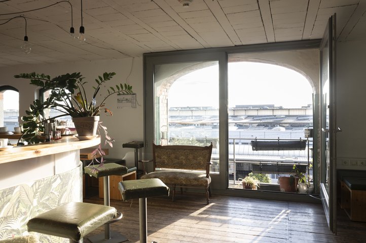 Sonnenlicht durchflutet den Raum des Café Lu der HfK Bremen, Pflanzen und Möbel im Vordergrund.