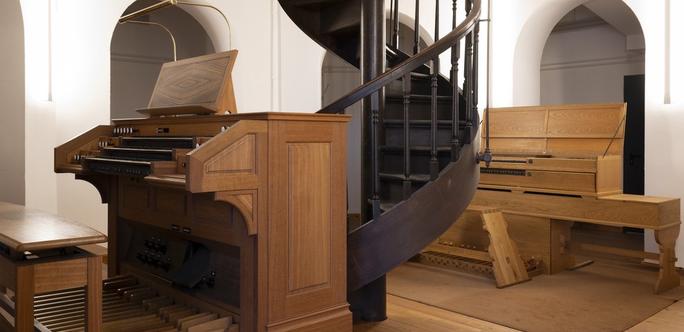 Innenansicht des Fachbereichs Musik der Hochschule für Künste Bremen an der Dechanatstraße mit hölzernen Orgeln und einer Wendeltreppe.