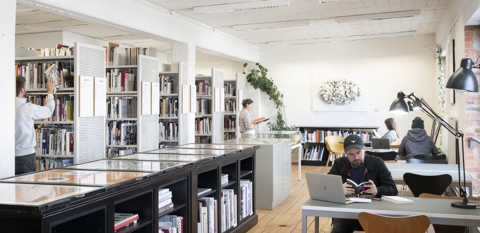 Lesebereich mit Personen, die in der Teilbibliothek Kunst und Design arbeiten.