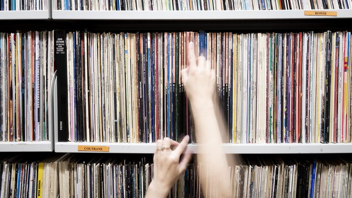 Close-up of a hand pulling a record from a shelf in the Klaus-Kuhnke Archive, HfK Bremen.