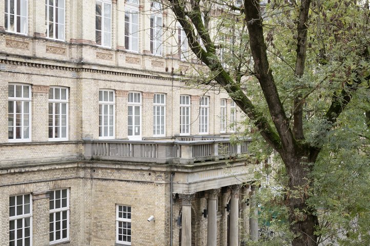 Historic building on Dechanatstraße, housing the University of the Arts Bremen Music Department. Features include large windows, detailed brickwork, and a tree in the foreground.
