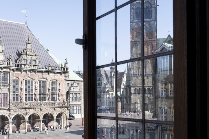 Blick auf den Marktplatz von Bremen mit historischen Gebäuden und einer Kirche.