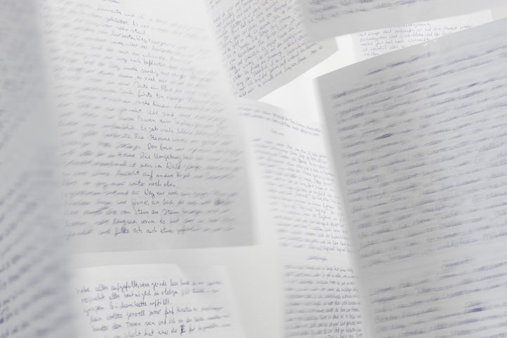 Close-up of overlapping handwritten text pages as design work.