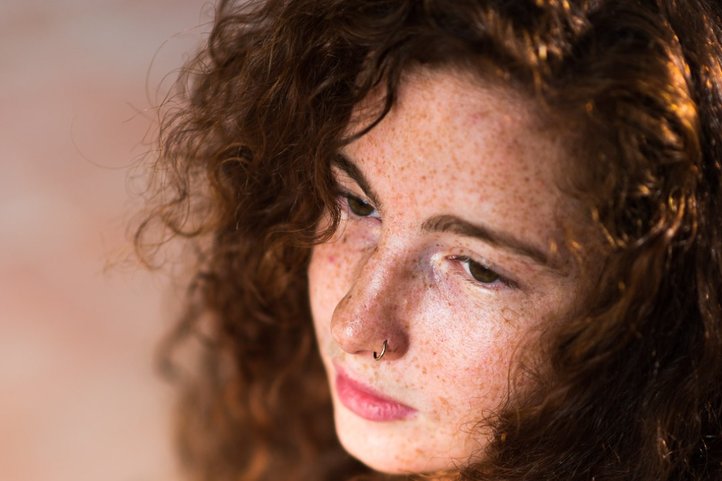 Porträt von Anna Lodone mit lockigem Haar, ein Streichinstrument haltend und einem nachdenklichen Ausdruck