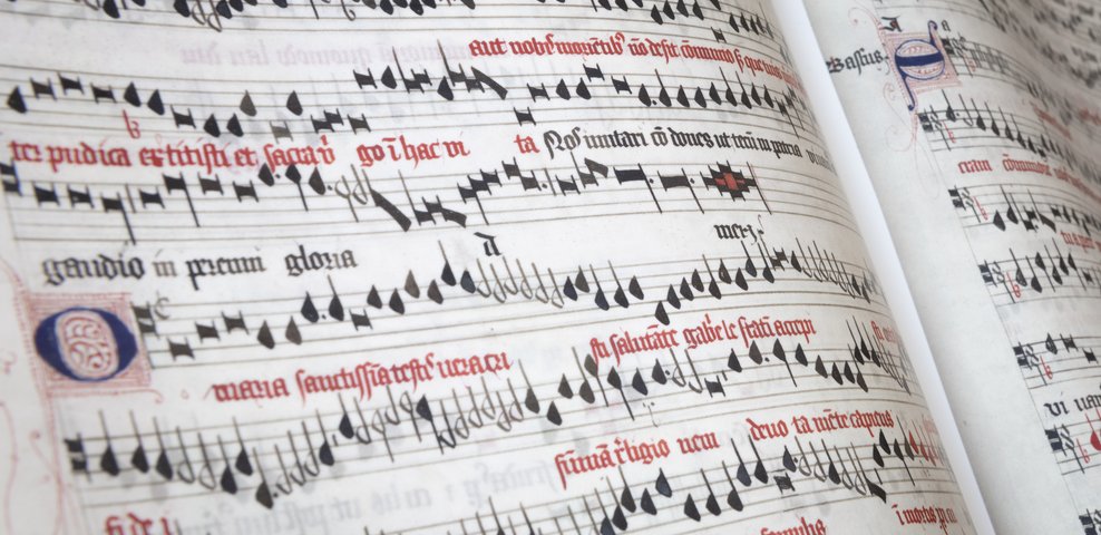 Historisches Notenmanuskript mit roter und schwarzer Notation.
