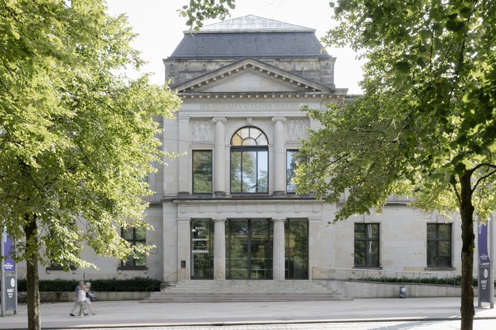 View of the Kunsthalle Bremen, a historic building with trees in the foreground and a decorative façade.