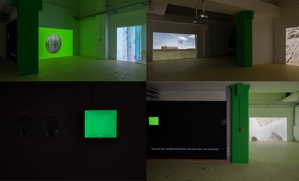 Vierteilige Videoinstallation von Shirin Mohammad mit grünlichem Licht und Untertiteln.