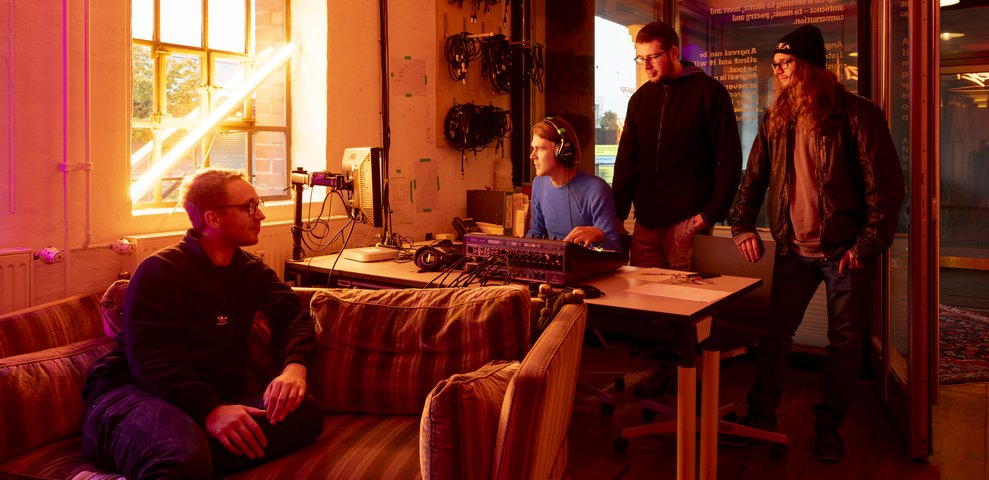 Radio Angrezi HfK Bremen, drei Personen arbeiten im beleuchteten Studio.