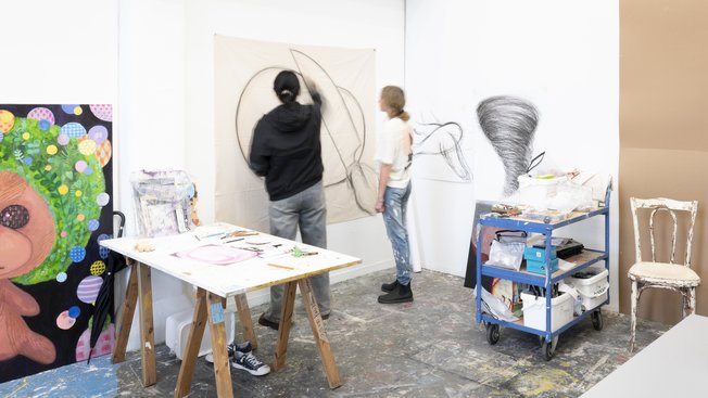 Studierende arbeiten in einem Studio der Freien Kunst der HfK Bremen an großformatigen Zeichnungen und Gemälden.