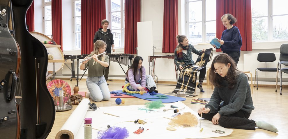Musikworkshop am Boden mit Instrumenten und Materialien.